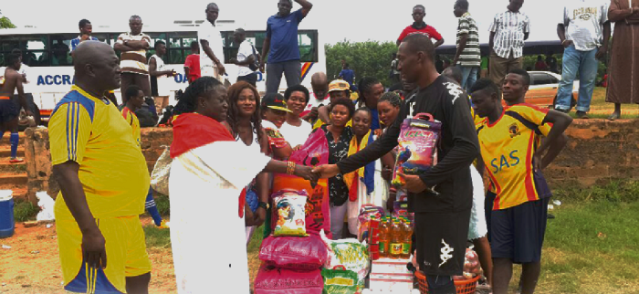 Madam Vicentia Deku presenting the items to Soulama Abdulaye while the team manager Saban Quaye, and others look on.